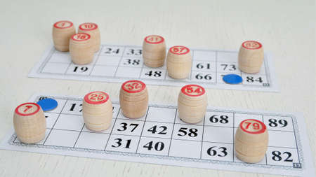 Wooden barrels lots a pouch and cards for playing lotto on the table. Board game of lotto or bingo.の写真素材