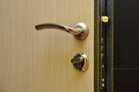 Modern style doorknob on a wooden door.の写真素材