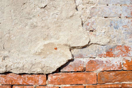 Empty old brick wall texture. Shabby facade of a building with damaged plaster.の写真素材