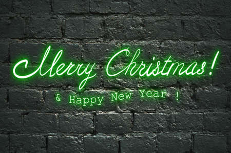 Neon green greeting lettering Merry Christmas and Happy New Year on black brick wall, neon lettering hand drawn calligraphyの写真素材