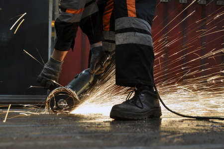 Worker at the factory cuts metal. sparks flyの写真素材
