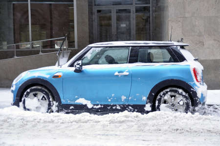 Moscow. Russian Federation - February 14, 2021: Mini Cooper car in a snowdrift near the roadside under a layer of snow. Winter.のeditorial素材