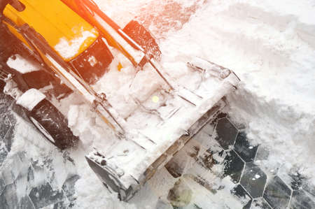 Removing snow accumulations using a tractor with attachments. Time of the year.の写真素材