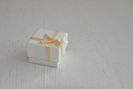 white gift box with punk ribbon on wooden background. Holiday.の写真素材