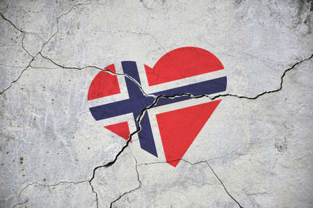 The symbol of the Norway national flag in the shape of a heart, on a cracked concrete wall. Concept.の写真素材