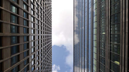 Fragments of modern glass city buildings on a sunny day. Looking from the bottom up.
