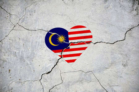 The symbol of the national flag of Malaysia in the form of a heart on a cracked concrete wall. concept.の写真素材