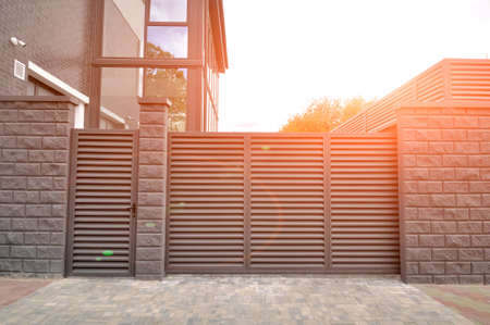 Modern entrance gate and gate to the territory of a private residential building. toneの写真素材