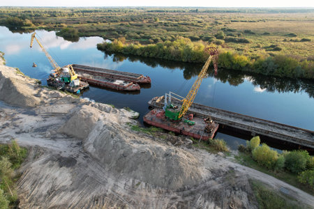 Large floating cranes unload bulk materials on the banks of the river.の写真素材