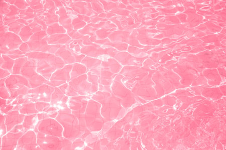 Swimming pool bottom caustics ripple and flow with waves background. Water surface texture in trend color 2023 Viva Magenta. view from above.の写真素材