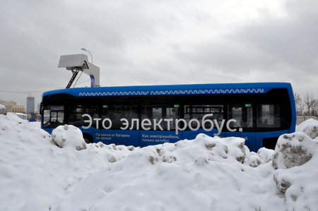 Electric bus at the charging station during recharging. Work in harsh winter conditions.のeditorial素材