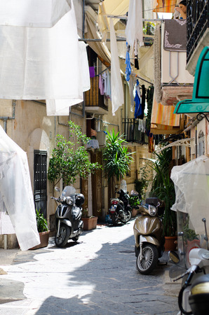 Narrow streets of Bari city, with scooters, balconies and bed linen on clothes lines, Puglia Apulia region, Southern Italyの写真素材