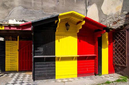 Wooden building with combination of Belgium Belgien and Germany Deutschland flag colors: black, red, yellow with doors and lamp lanternの写真素材