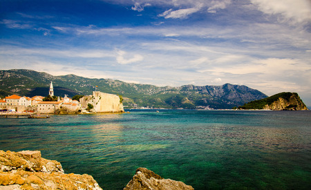 Old town Budva with stone citadel fortress, medieval buildings, red tiled roofs, chapel of Saint Ivan church, marine, bay, range of mountains, Island of St. Nicholas and Adriatic Riviera, Montenegroのeditorial素材