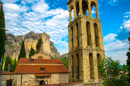 Bell tower, chapel and church in front of mountains and rocks with famous Meteora Monasteries,...