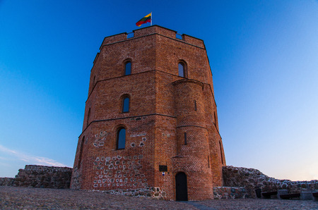 Medieval old Castle Tower Of Gediminas (Gedimino) on hill with Lithuanian national flag above at sunset, Vilnius, Lithuaniaのeditorial素材
