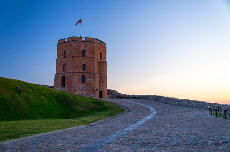 Medieval old Castle Tower Of Gediminas (Gedimino) on hill with Lithuanian national flag above at sunset, Vilnius, Lithuaniaのeditorial素材