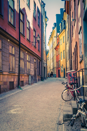 Traditional typical sweden narrow street with paving stones, bikes and colorful buildings in old historical town quarter Gamla Stan of Stadsholmen island, Stockholm, Swedenの写真素材