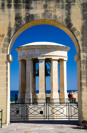 World War II Siege Bell War Memorial through archs in the Lower Barrakka Gardens, Valletta, Maltaの写真素材