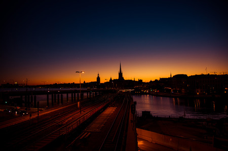 Silhouette of Stockholm cityscape skyline with Riddarholmen Church spires, City Hall Stadshuset tower, bridge over Lake Malaren in Gamla Stan at sunset, dusk, twilight and purple orange sky, Swedenの写真素材