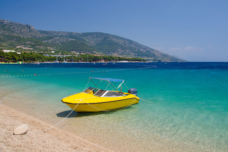 Yellow boat on beautiful sea water near the cape Zlatni Rat beach (Golden Horn) of Brac Island,...