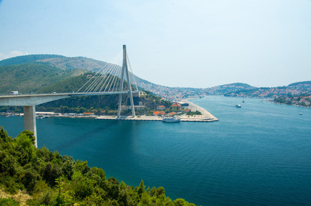 The Franjo Tudjman cable-stayed bridge and blue lagoon with boats and ships in harbor of Dubrovnik, Dalmatia, Croatia, Europeの写真素材