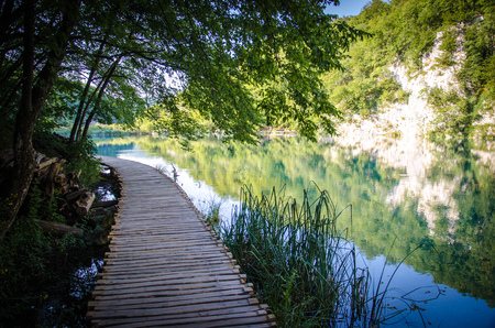 Wooden path boardwalk bridge on the blue colored water lake, National park Plitvice Lakes, Croatia, Europeの写真素材