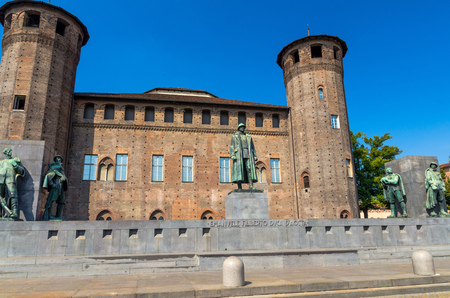 Medieval old Acaja Castle with brick towers and Monumento Emanuele Filiberto Duca d'Aosta on Castle Square Piazza Castello in historical centre of Turin Torino city, clear blue sky, Piedmont, Italyのeditorial素材
