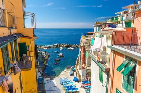 Top view of small harbor with fishing colorful boats, multicolored houses with balconies and shutter...