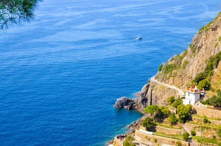 Top view of rocks and cliffs coastline of Riviera di Levante of National park Cinque Terre Coast, blue water of Ligurian and Mediterranean Sea in sunny day, Riomaggiore village, Liguria, Italyの写真素材