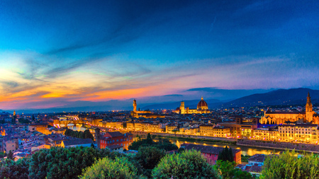 Top aerial panoramic evening view of Florence city with Duomo Santa Maria del Fiore cathedral, Arno river, Basilica di Santa Croce and Palazzo Vecchio palace at night dusk, city lights, Tuscany, Italyの写真素材