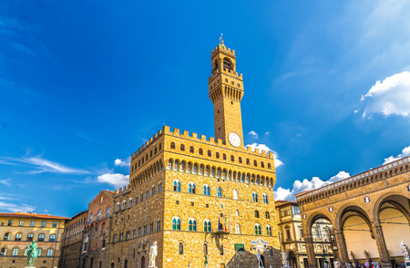 Palazzo Vecchio palace with bell tower with clock and Loggia dei Lanzi on Piazza della Signoria square in historical centre of Florence city, blue sky white clouds, Tuscany, Italyのeditorial素材
