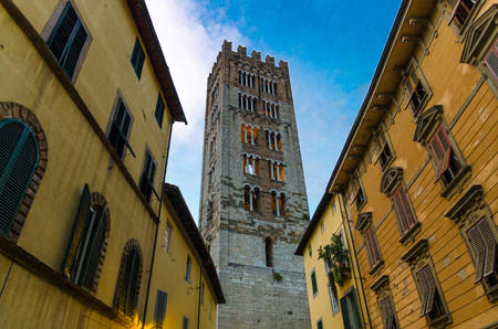 Bell tower of Chiesa di San Frediano catholic church view below from narrow street in historical centre of old medieval town Lucca, evening view, Tuscany, Italyの写真素材