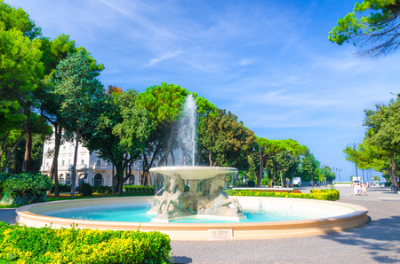 Quattro cavalli Four horses fountain with turquoise water in Parco Federico Fellini park with green trees in touristic city centre Rimini with blue sky background, Emilia-Romagna, Italyの写真素材