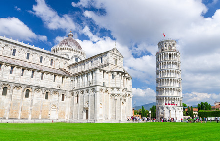 Pisa Cathedral Duomo Cattedrale and Leaning Tower Torre on Piazza del Miracoli square green grass lawn, blue sky with white clouds background in sunny day, Tuscany, Italyの写真素材