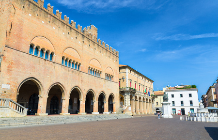 Palazzo dell'Arengo palace building with arches and Pope Paul V statue on Piazza Cavour square in old historical touristic city centre Rimini with blue sky background, Emilia-Romagna, Italyのeditorial素材