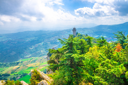 Republic San Marino Terza Torre Montale third fortress tower with brick walls on Monte Titano stone rock with green trees, aerial top panoramic view of landscape valley and hills of suburban districtのeditorial素材