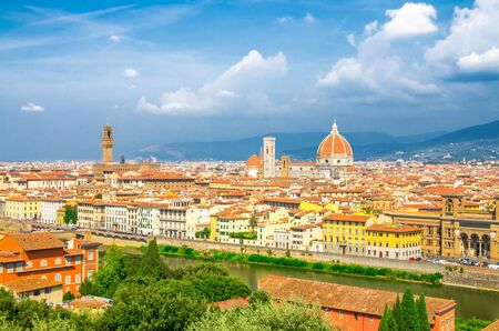 Top aerial panoramic view of Florence city with Duomo Cattedrale di Santa Maria del Fiore cathedral, buildings houses with orange red tiled roofs and Arno river, blue sky white clouds, Tuscany, Italyの写真素材