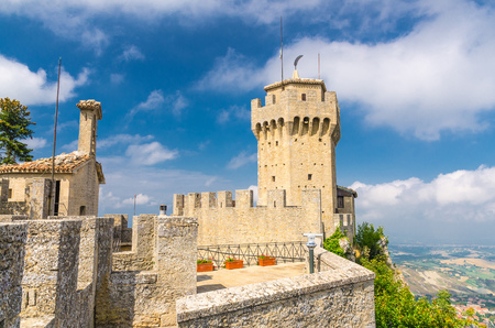 Republic San Marino Seconda Torre La Cesta second fortress tower with merlons and brick walls on Mount Titano stone rock, blue sky white clouds backgroundのeditorial素材
