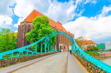 Roman Catholic parish Saint Mary church NMP on Sand island Wyspa Piasek, view through arch of Tumski bridge over Odra Oder river in old town historical city centre of Wroclaw, Polandの写真素材
