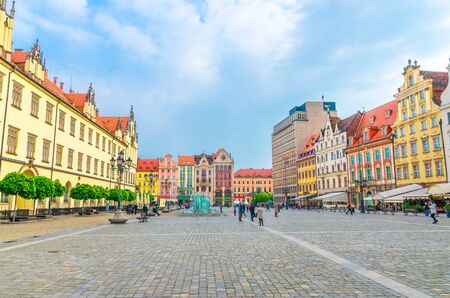 Row of colorful traditional buildings with multicolored facades, New City Hall, glass fountain on Rynek Market Square in old town historical city centre of Wroclaw, Polandの写真素材