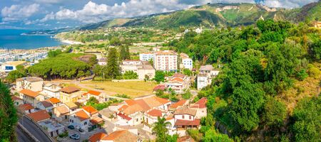 Aerial panoramic view of Tropea town with port, houses, Tyrrhenian Sea, green hills and mountains of Calabria, Southern Italyの写真素材