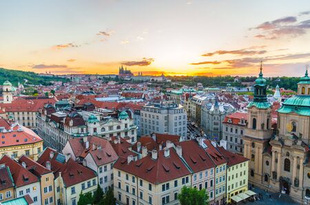 Top aerial panoramic view of Prague Old Town historical city centre with red tiled roof buildings and Prague Castle, St. Vitus Cathedral in Hradcany district in evening sunset, Bohemia, Czech Republicの写真素材