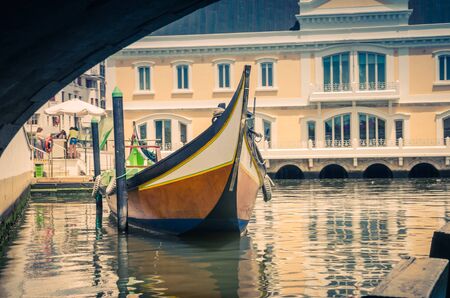 Portugal Aveiro in summer, little Venice of Portugal, Vouga river, Portugal Aveiro Chanel, typical tourist boat, orange wooden boat on the river, view of the boat through the arch of the  bridgeの写真素材