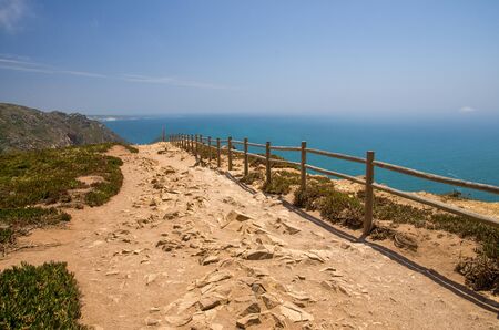Portugal, Cabo da Roca, The Western Cape Roca of Europe,  hiking trails on the Cape Roca, ocean view from the Cape  Roca, cliff above the Atlantic ocean, azure water in the Atlantica, wooden handrails over the cliffの写真素材