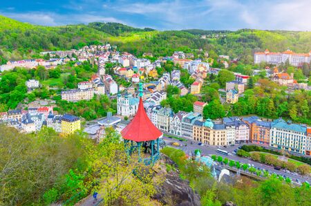 Karlovy Vary (Carlsbad) historical city centre top aerial view with colorful beautiful buildings, Slavkov Forest hills with green trees and Deer Jump Jeleni Skok Lookout, West Bohemia, Czech Republicの写真素材