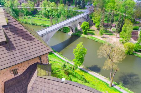Bridge over Eger river top aerial view from walls of Loket Castle Hrad Loket gothic style building on massive rock, green grass and trees, Karlovy Vary Region, West Bohemia, Czech Republicのeditorial素材