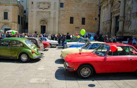 Lecce, Italy - April 23, 2017: Row of colourful vintage classic retro automobiles cars with color baloons parked at the central square Piazza del Duomo during exhibition, Puglia Apulia region, Southern Italyのeditorial素材