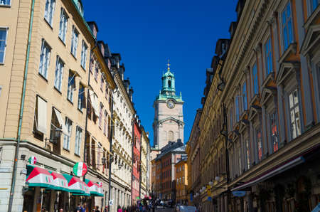 Sweden, Stockholm, May 31, 2018: typical narrow streets with cafes, restaurants, shops in old historical town quarter Gamla Stan of Stadsholmen island with view of Cathedral of St Nicholas Storkyrkanのeditorial素材