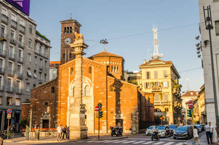 Milan, Italy, September 8, 2018: Basilica di San Babila church with clock tower and column with lion on top between modern buildings on Piazza Babila square in historical centre of Milano cityのeditorial素材